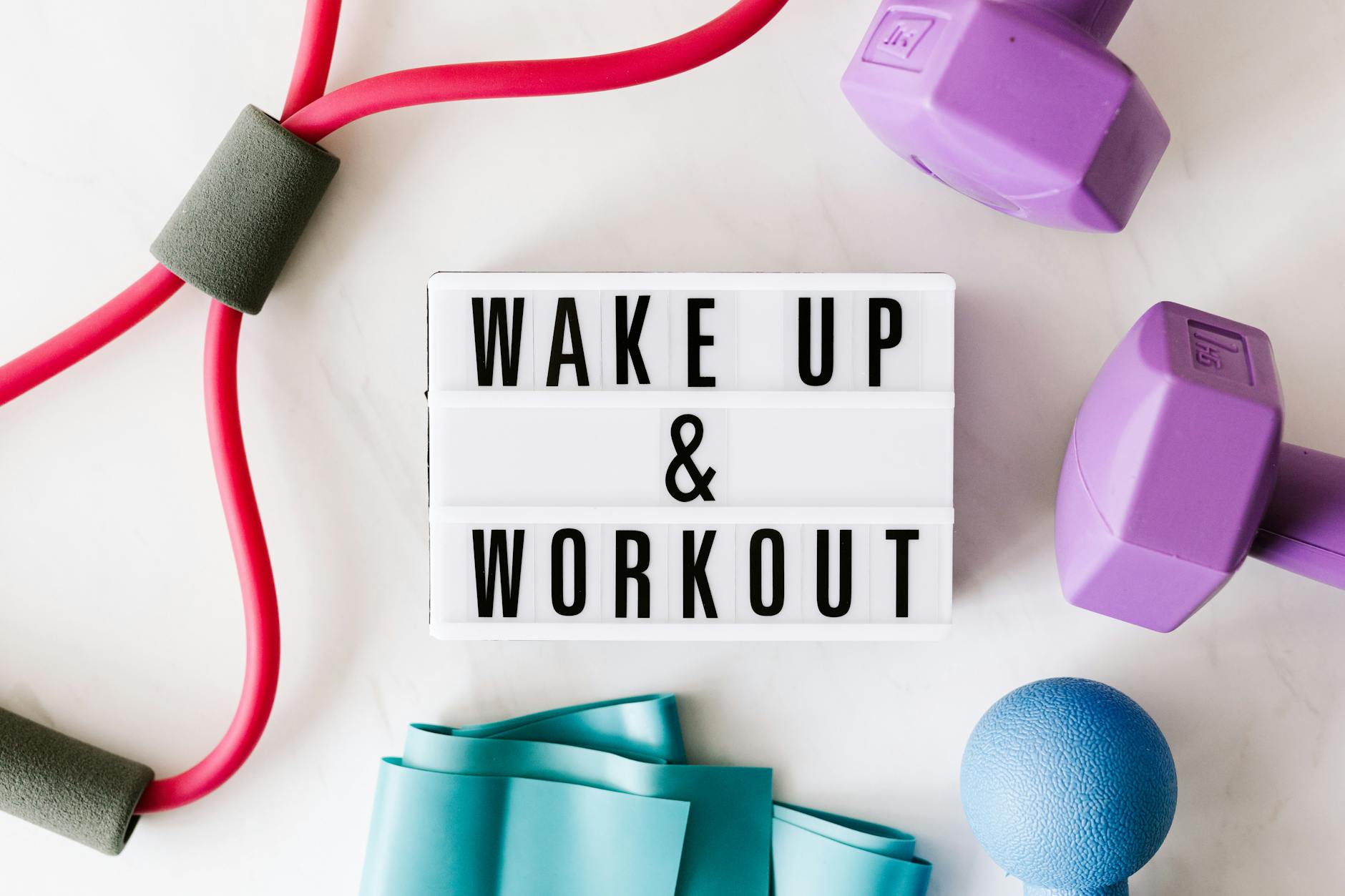 Flat lay of fitness equipment with a motivational slogan for exercise inspiration.