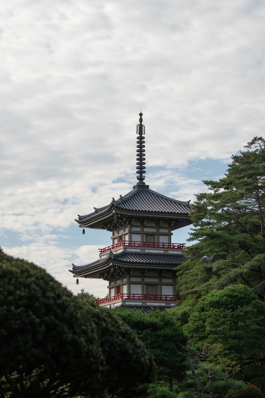 Serene view of a traditional Japanese pagoda surrounded by lush greenery in a peaceful garden.